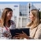 Zwei Personen besprechen Serviceleistungen mit Tablet vor Außengeräten