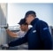 Zwei Servicetechniker prüfen und reparieren eine HLK-Anlage im Außenbereich