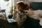Das Bild zeigt eine Frau und einen Hund vor einem Laptop.