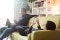 The image shows two adults on the sofa, each holding a smartphone in their hands