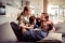 Das Bild zeigt eine Familie auf einem Sofa freudig lachend.
